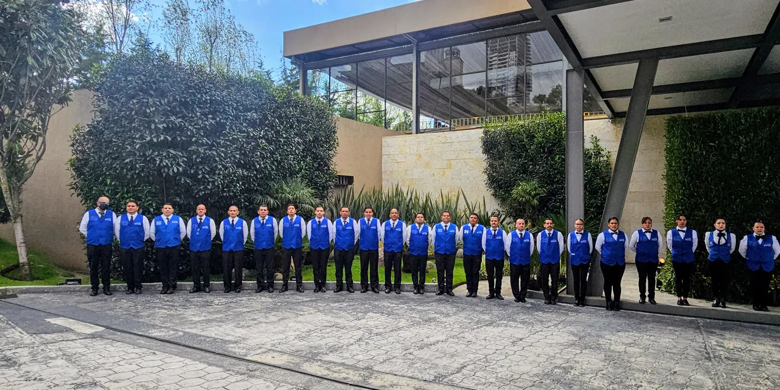 Equipo amplio de VARMUSA uniformado y formado frente a un acceso cubierto