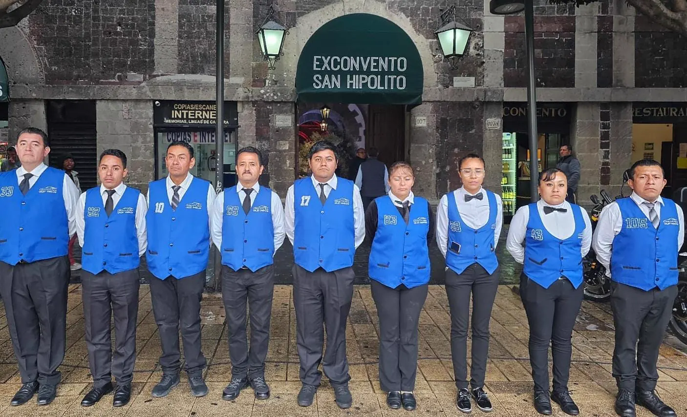 Equipo de valet uniformado formado frente a una fachada de piedra