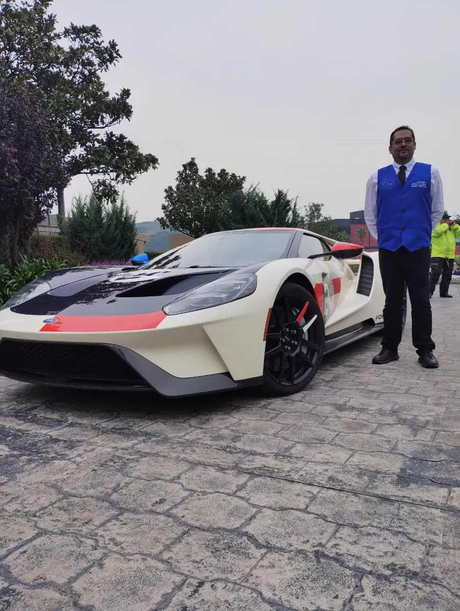 Colaborador de valet uniformado junto a un automóvil deportivo